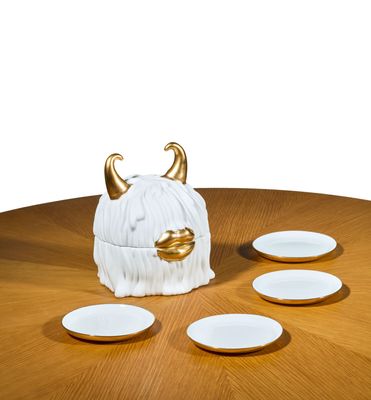 une photo d'une table sur laquelle se trouvent des assiettes et un vase