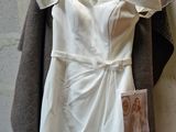 a white dress hanging on a hanger on a wall