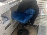 a blue chair sitting in front of a desk with a laptop on it