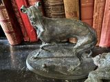 une statue représentant un chien assis au sommet d'une bibliothèque