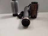 a hair dryer and a hair brush on a table