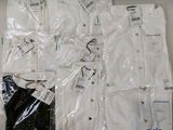 several white shirts are wrapped in plastic bags on a table