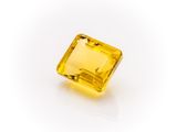 a yellow sapphire stone on a white background