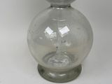 a glass vase with a clear base on a white surface