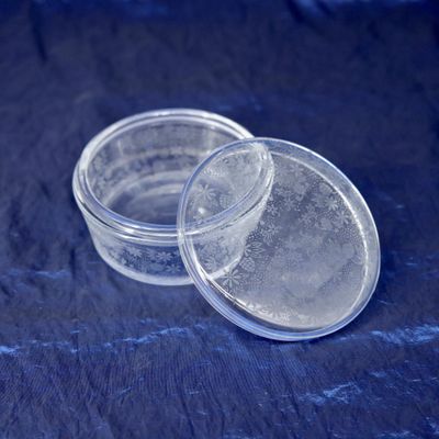 two clear plastic containers sitting on top of a blue cloth