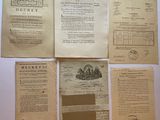 several old papers are sitting on a table with a clock
