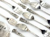 a lot of silver spoons and forks on the table