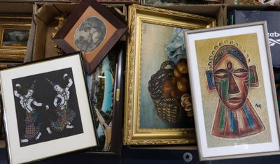 une boîte remplie d'œuvres d'art encadrées et de photos posée sur une table