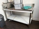 une table en métal sur laquelle se trouve une poubelle