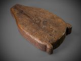 an old wooden paddle sitting on top of a gray surface