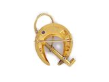 a close up of a gold broochle with a hammer on it