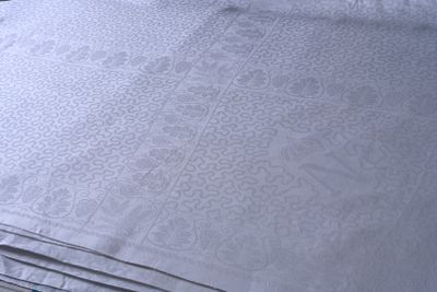 une pile de draps blancs sur un lit recouvert d'une couette bleue