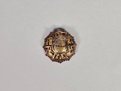une image représentant un insigne de couleur dorée orné d'une couronne