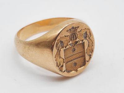 un gros plan d'une bague en or sur laquelle est gravé un blason