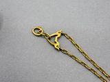 a close up of a gold chain with a bird on it