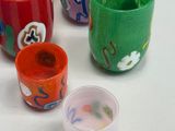 five cups with different designs on them sitting on a table