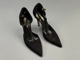 une paire de chaussures noires à talons hauts sur une surface blanche