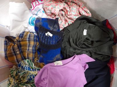 a pile of clothes sitting on top of a bed