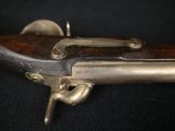 a close up of a gun with a wooden handle on a black background