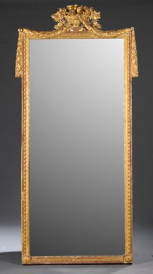 un miroir richement décoré, avec un cadre doré sur fond gris