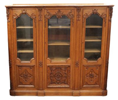 une bibliothèque en bois avec des portes vitrées et des sculptures sur la façade