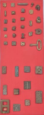 une vitrine rouge sur laquelle sont disposés tout un tas d'objets métalliques