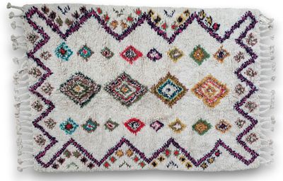 a white rug with multi colored diamonds and fringes
