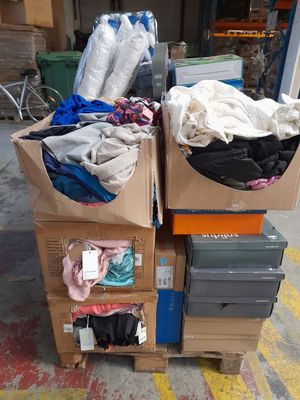 un tas de vêtements posé sur un carton dans la rue
