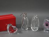 trois vases en verre et une boîte rouge sur la table