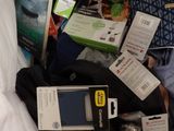 a pile of electronics and other items on a bed