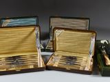 trois valises ouvertes posées sur une table, contenant des couteaux