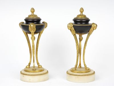 une paire de vases noirs et dorés posés sur un socle en marbre
