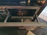 an open drawer in the middle of a kitchen
