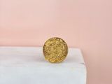 a gold coin sitting on top of a marble block