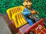 une figurine représentant un homme au volant d'une petite voiture
