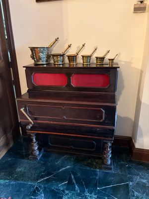 une photo d'une pièce avec un piano sur lequel sont posés des pots