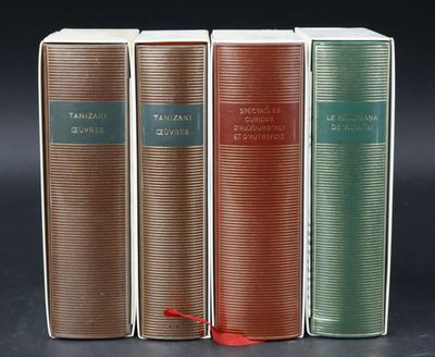 three books are lined up in a row on a black surface