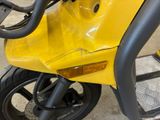 a close up of a yellow motorcycle parked in a garage