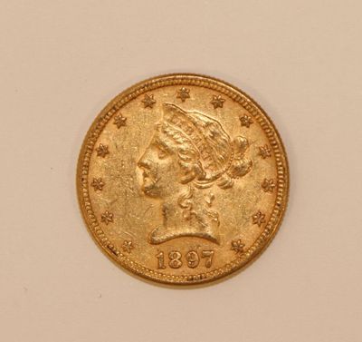 a close up of a gold coin on a white surface