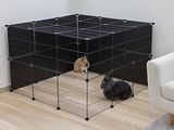 un chien assis dans une cage dans le salon