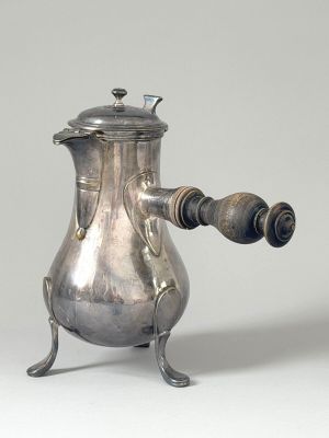 a silver coffee pot with a wooden handle on a stand