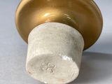 a close up of a gold knob on a white table
