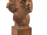 une image représentant une sculpture représentant une tête de femme posée sur un socle en bois