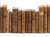 plusieurs vieux livres empilés sur une surface blanche