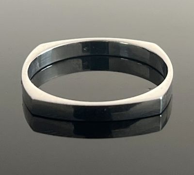 un gros plan d'une bague en argent posée sur une table