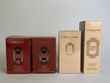 three boxes of perfume sitting next to each other on a white surface