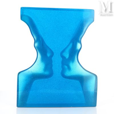 un sablier bleu posé sur une table blanche