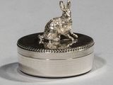 a silver rabbit sitting on top of a silver box
