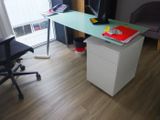 un bureau avec un ordinateur et une chaise dans une pièce