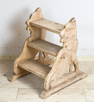 un petit escabeau en bois sur lequel est posé un chien